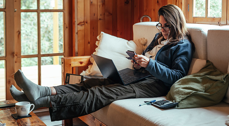 Woman sitting on couch using her phone
