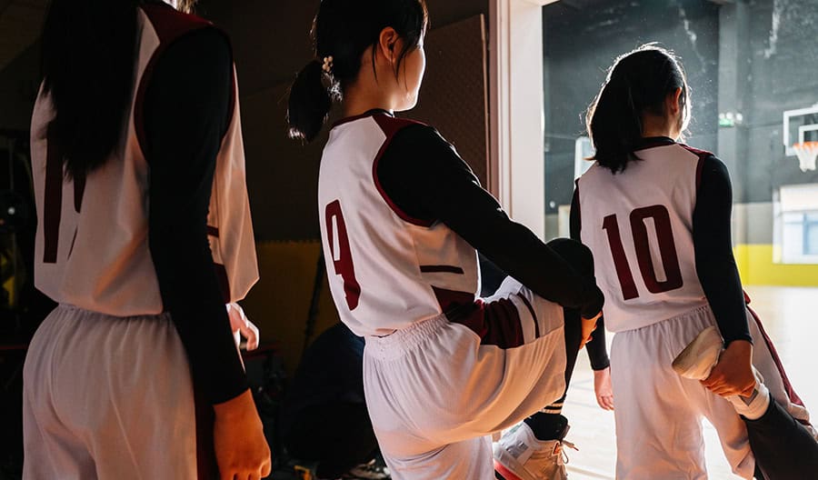 Three girls preparing to play a sports game
