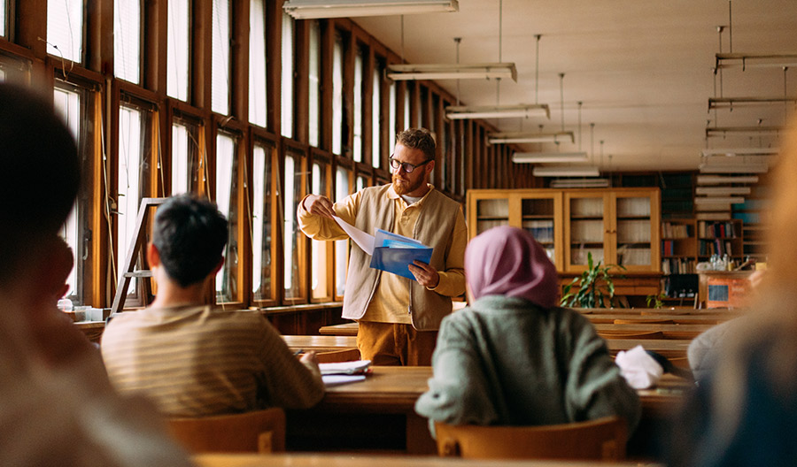 Teacher giving lecture to students in a library