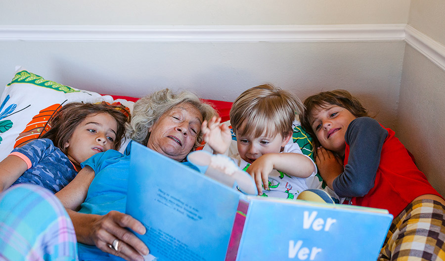 Kids reading book with grandma