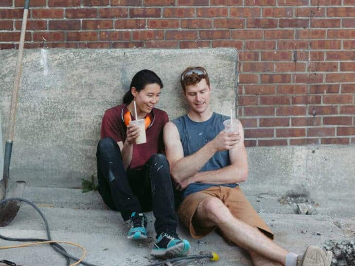 Woman and man sitting on floor of home renovation