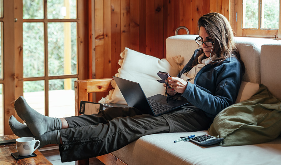 Woman sitting on a couch with her feet up on a table.
