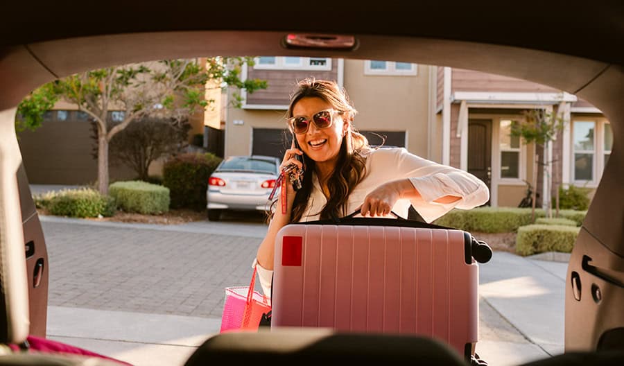 Woman-Smiling-Getting-Suitcase-From-Car
